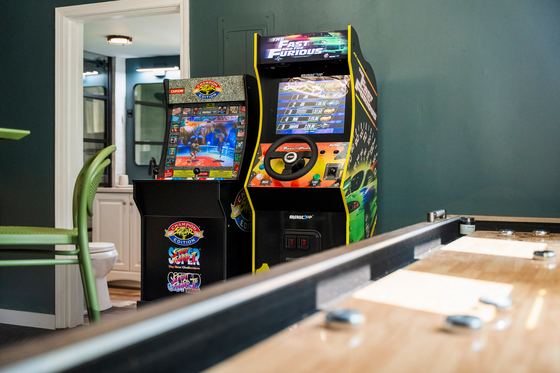 Arcade cabinets beside the length of the shuffleboard table.