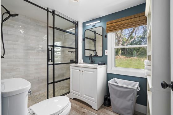 The full bathroom with a glass shower, vanity and blue-grey walls.