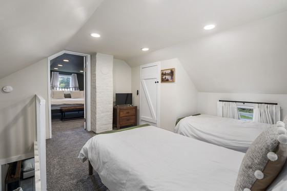 Upstairs single beds with a mirror and dresser.