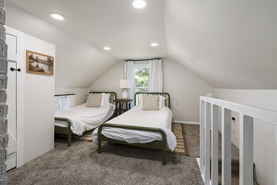 Upstairs bedroom with two single beds under a sloped ceiling.