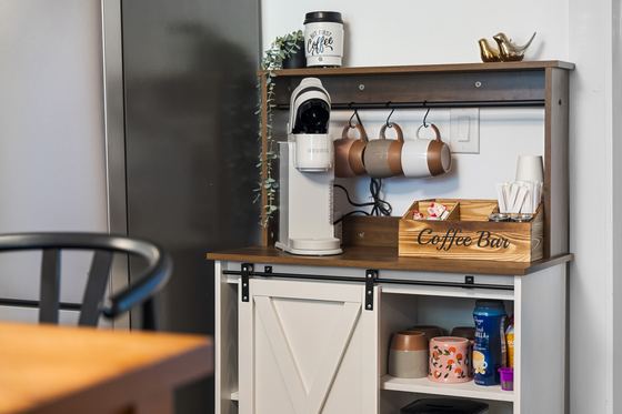 Coffee bar station with hanging mugs, grinder and supplies.