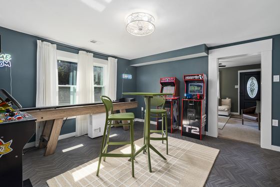 The game room: shuffleboard table, arcade cabinets and a high-top table.