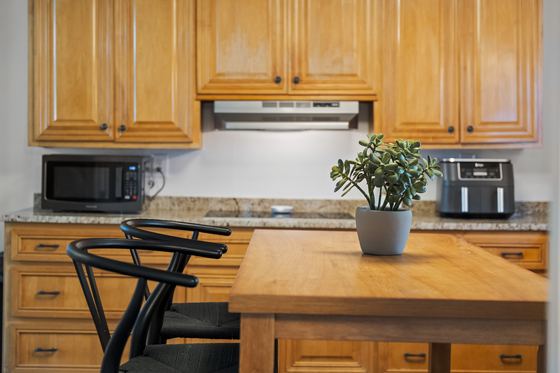 Kitchen counter and island with microwave and coffee maker.