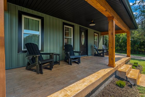 Adirondack chairs lined up along the covered porch.
