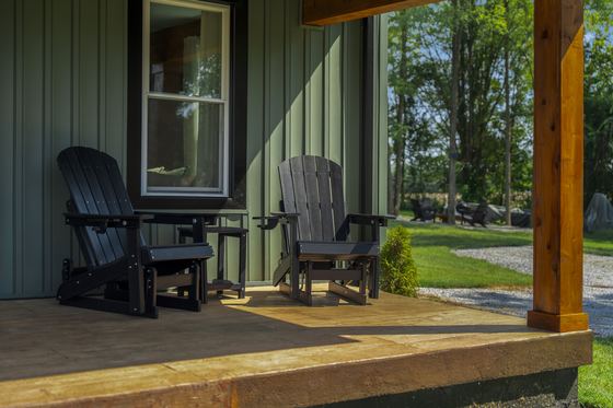 Corner of the porch with chairs looking out over the yard.